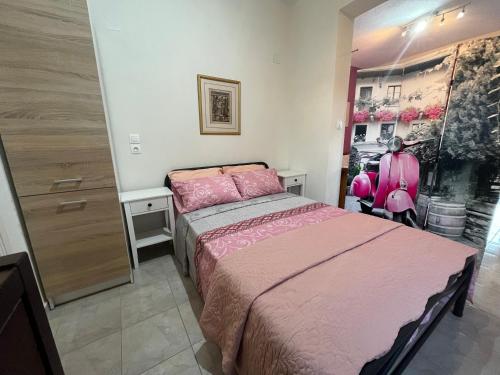 a bedroom with a bed with pink sheets and a dresser at Villa Leonidas KOUTSOUPIA in Kokkino Nero
