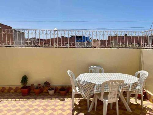 a table and chairs on a patio with a balcony at Modern fully equipped two story appartement/duplex in Safi