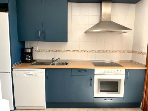 a kitchen with blue cabinets and a sink at Ayamonte - Vista Esuri Golf and Beach in Huelva