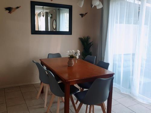 mesa de comedor con sillas azules y espejo en Casa condominio Pucón, piscina, en Pucón