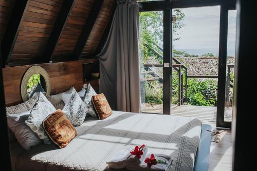 a bedroom with a bed and a large window at Bohemia Experience in Santa Teresa Beach