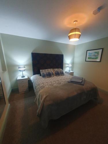 um quarto com uma cama grande e 2 candeeiros em Junior Suite Town Centre em Dungarvan