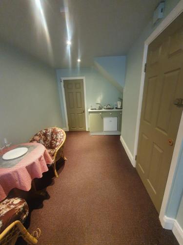 a room with a table and chairs and a kitchen at Junior Suite Town Centre in Dungarvan