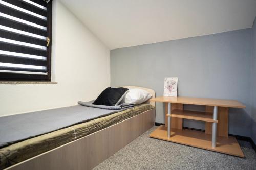 Cette petite chambre comprend un lit et une table. dans l'établissement Apartman Amina, à Mostar