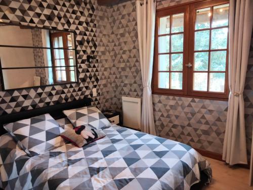 Un dormitorio con una cama con un osito de peluche. en A la campagne 25 km de Périgueux en La Peyzie
