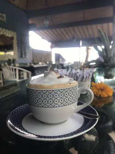 een kop koffie op een schotel op een tafel bij Spacious Private Pool Apartment-Beachside Resort in Candidasa