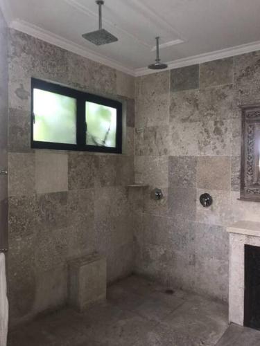 a bathroom with a tub and a window on the wall at Spacious Private Pool Apartment-Beachside Resort in Candidasa