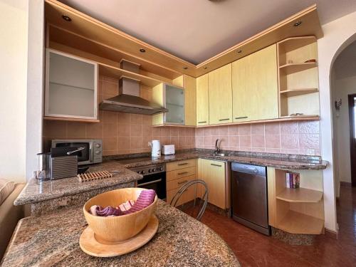 a kitchen with wooden cabinets and a bowl on a counter at Casa Sara in Costa Calma