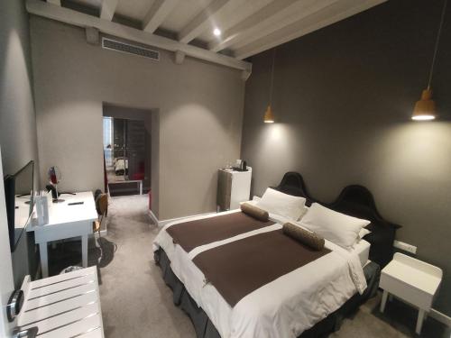 a bedroom with a large bed and a desk at XII Century Heritage Hotel in Trogir