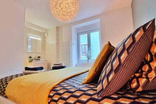 a large bed in a bedroom with a chandelier at La Buhl verte - Chic et Moderne - Calme - Fibre - Relax BNB in Buhl