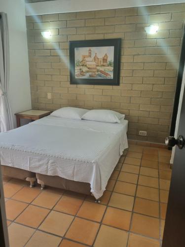 a bed in a room with a brick wall at San Jeronimo Cabaña in San Jerónimo