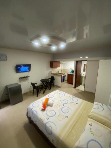 een slaapkamer met een groot bed en een woonkamer bij Confort apartaestudio completo Aire acondicionado Todo independiente in Cali
