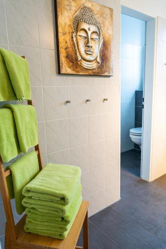a bathroom with a painting of a head on the wall at Fewo Art City-Studio Kassel 7, groß, modern, citynah, kostenfreie Parkplätze, Süd-Balkon, ruhig, Herkulesblick, voll ausgestattet in Kassel