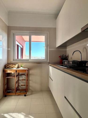 a kitchen with a sink and a window at T3 beach front in São João da Caparica in Costa da Caparica