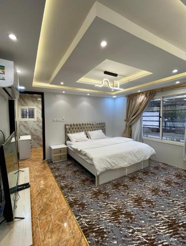 1 dormitorio con 1 cama grande y TV. en شاليه الجوهرة الدرب, en Ad Darb