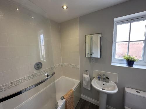 a bathroom with a sink and a tub and a toilet at Newt's Place in Filey