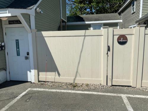 a white fence next to a house with a garage at Portside Tavern in Hyannis