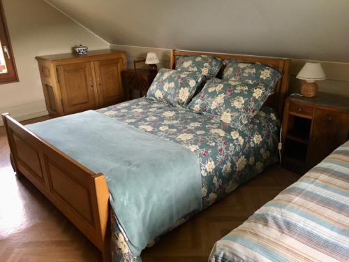 um quarto com uma cama com um cobertor azul em Le Chalet de la REPANDISE em Laveline-du-Houx