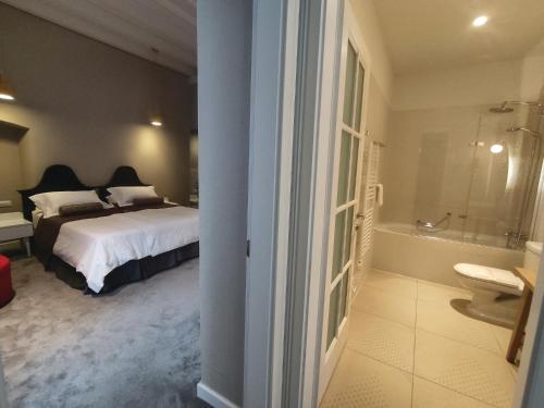 a bedroom with a bed and a bathroom with a tub at XII Century Heritage Hotel in Trogir