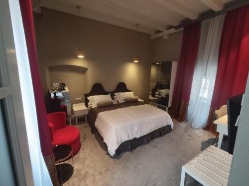 a bedroom with a bed and a red chair at XII Century Heritage Hotel in Trogir