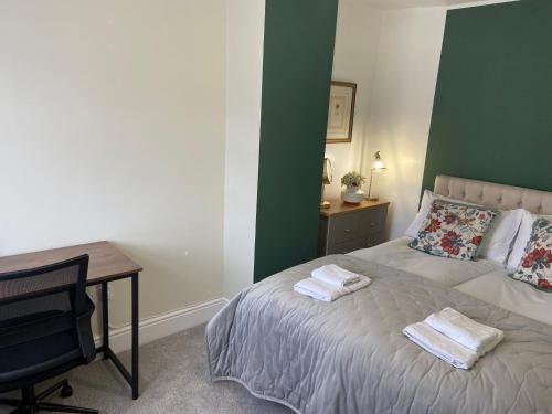 a bedroom with a bed with two towels on it at The Cosy House in Hugglescote