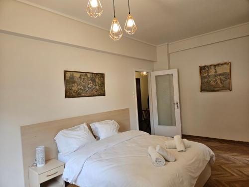 1 dormitorio con 1 cama blanca y 2 toallas en F23 en Athens