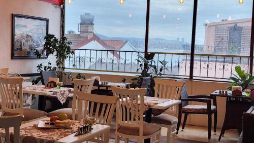 een restaurant met tafels en stoelen en een groot raam bij Oceans 7 Hotel in Istanbul