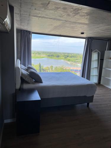 1 dormitorio con cama y ventana grande en Loft con vista al río en San Pedro