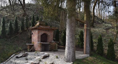 a brick fireplace next to a tree in a forest at Apartmani Katruža in Sveti Martin na Muri