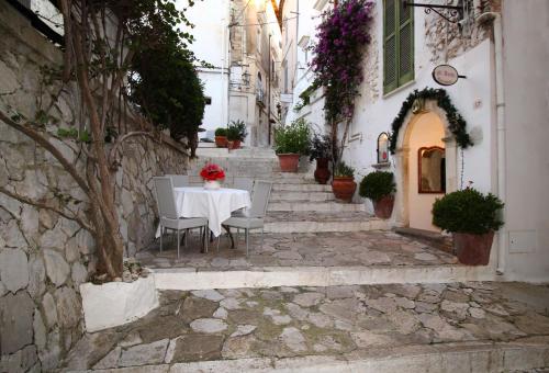 a table and chairs on a stone walkway in an alley at Il Mare Nel Pozzo Sperlonga Centro Storico Tutti i servizi sotto casa, a 100 mt dal mare Parcheggio multilivello adiacente, lasci la macchina e fai tutto a piedi! in Sperlonga