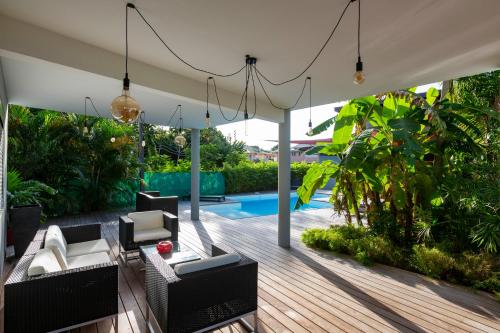 un patio al aire libre con muebles y una piscina en Résidence HIBISCUS 5 étoiles en Cayenne