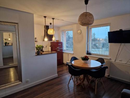 Una sala de estar con una mesa y una cocina. en Apartament Sportowa, en Gryfice