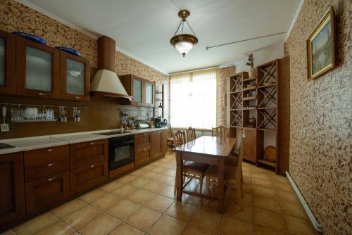 a kitchen with a wooden table and a dining room at Brech Resort&Spa in Gurinovka Staraya