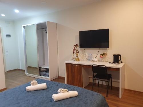 um quarto com uma secretária e uma cama com 2 toalhas em The Fresh Wave hotel em Batumi
