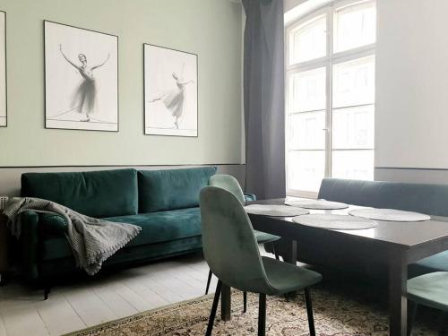 a living room with a couch and a table and chairs at Rynek - Cozy Retro Apartment near to Main Square in Wrocław