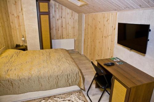 a bedroom with a bed and a desk and a television at Brech Resort&Spa in Gurinovka Staraya