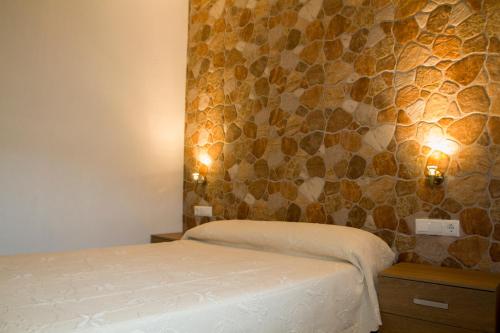a bedroom with a bed and a stone wall at La Vega in Tarifa