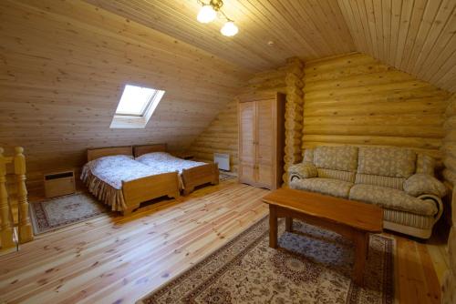 a bedroom with a bed and a couch in a room at Brech Resort&Spa in Gurinovka Staraya