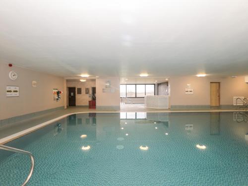 a large swimming pool in a building at Honeybee Cottage in Penrith