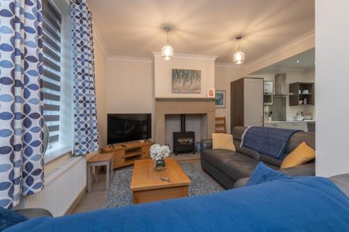 a living room with a couch and a tv at Sleeps 6 4 bedrooms 2 minute walk to the Square Hosted Happy Valley Cast in Hebden Bridge