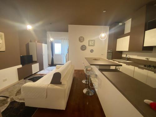 sala de estar con sofá blanco y cocina en Domus Romanae in centro storico, en Peschiera del Garda