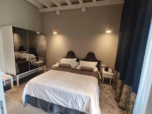 a bedroom with a large bed and a large mirror at XII Century Heritage Hotel in Trogir