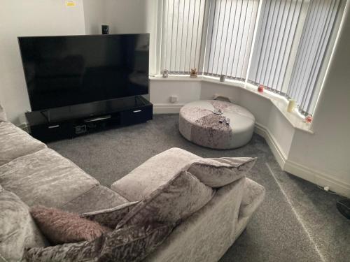 a living room with a couch and a flat screen tv at Danny holiday home in Blackpool