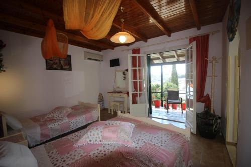 sypialnia z 2 łóżkami i dużym oknem w obiekcie Niky's cottage w mieście Paleokastritsa