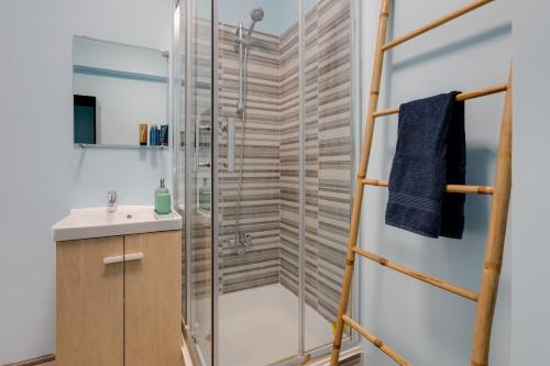 y baño con ducha y lavamanos. en MAX CRIB - Seafront 2 bedroom apart with AC and private parking in Armação de Pera, en Armação de Pêra