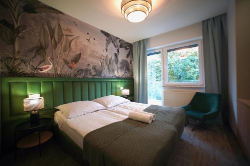 a bedroom with a bed and a green wall at Pensjonat Przedwiośnie in Jurata