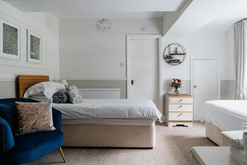 a bedroom with a bed and a blue chair at Lee House in Lynton