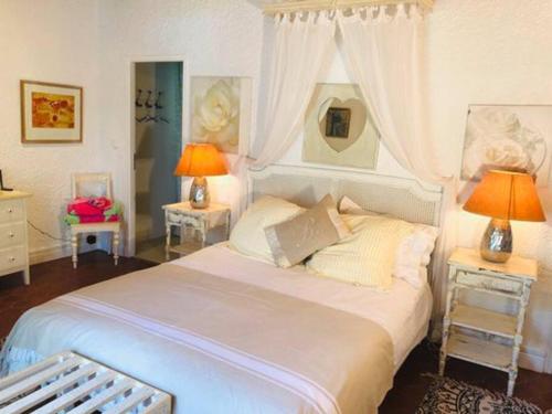 une chambre avec un grand lit blanc avec deux lampes dans l'établissement La Grande Barbotière Villa d'Exception, à Saint-Vivien