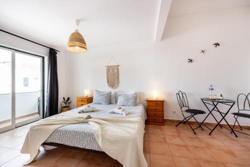 1 dormitorio con 1 cama, mesa y sillas en 3 Marias Guest House B&B en Lagos