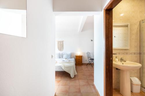 3 Marias Guest House B&B في لاغوس: حمام مع مغسلة وسرير في الغرفة